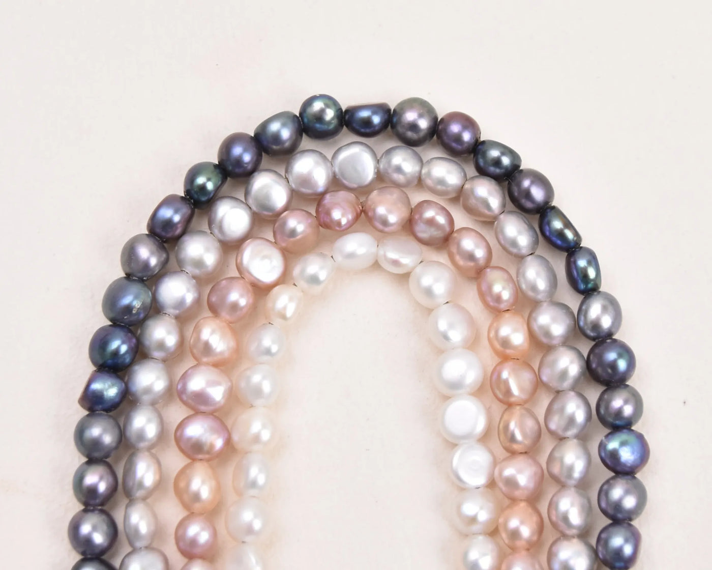 All the pearl colors for the Crown Anklets on a white background in an arch