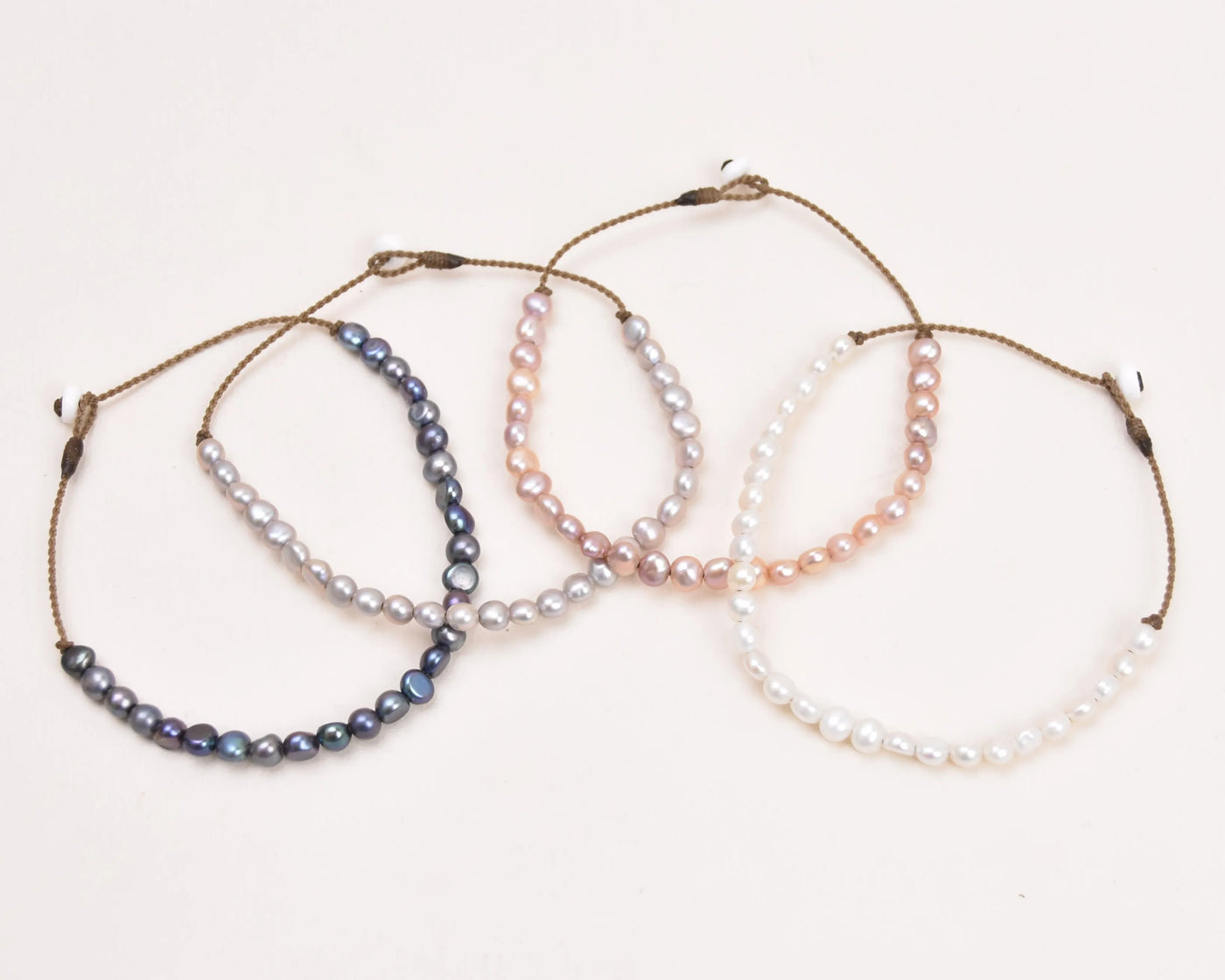 all the color pearls for the crown anklets in an arch with a white background