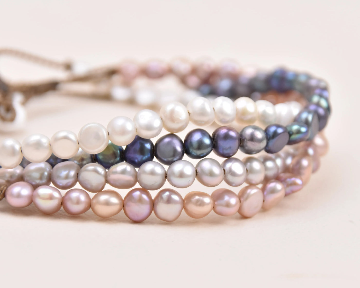 closeup up of a stack of the crown anklets with every color option of pearls