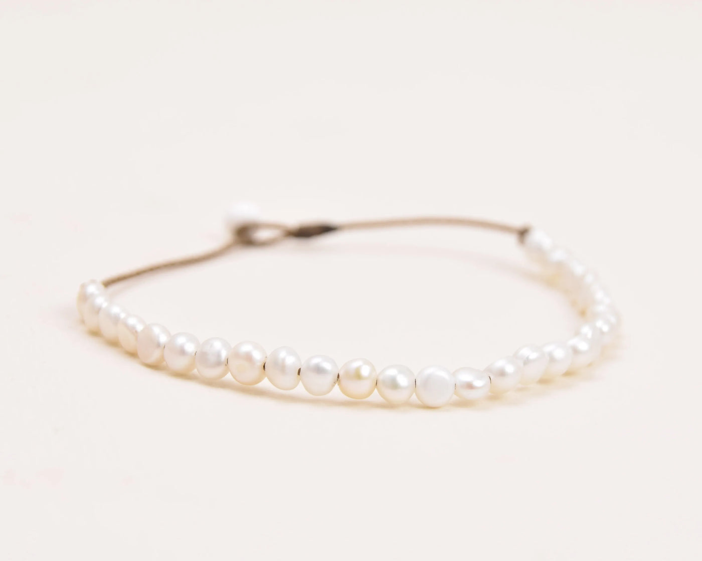 the crown anklet in white pearls closeup with a white background