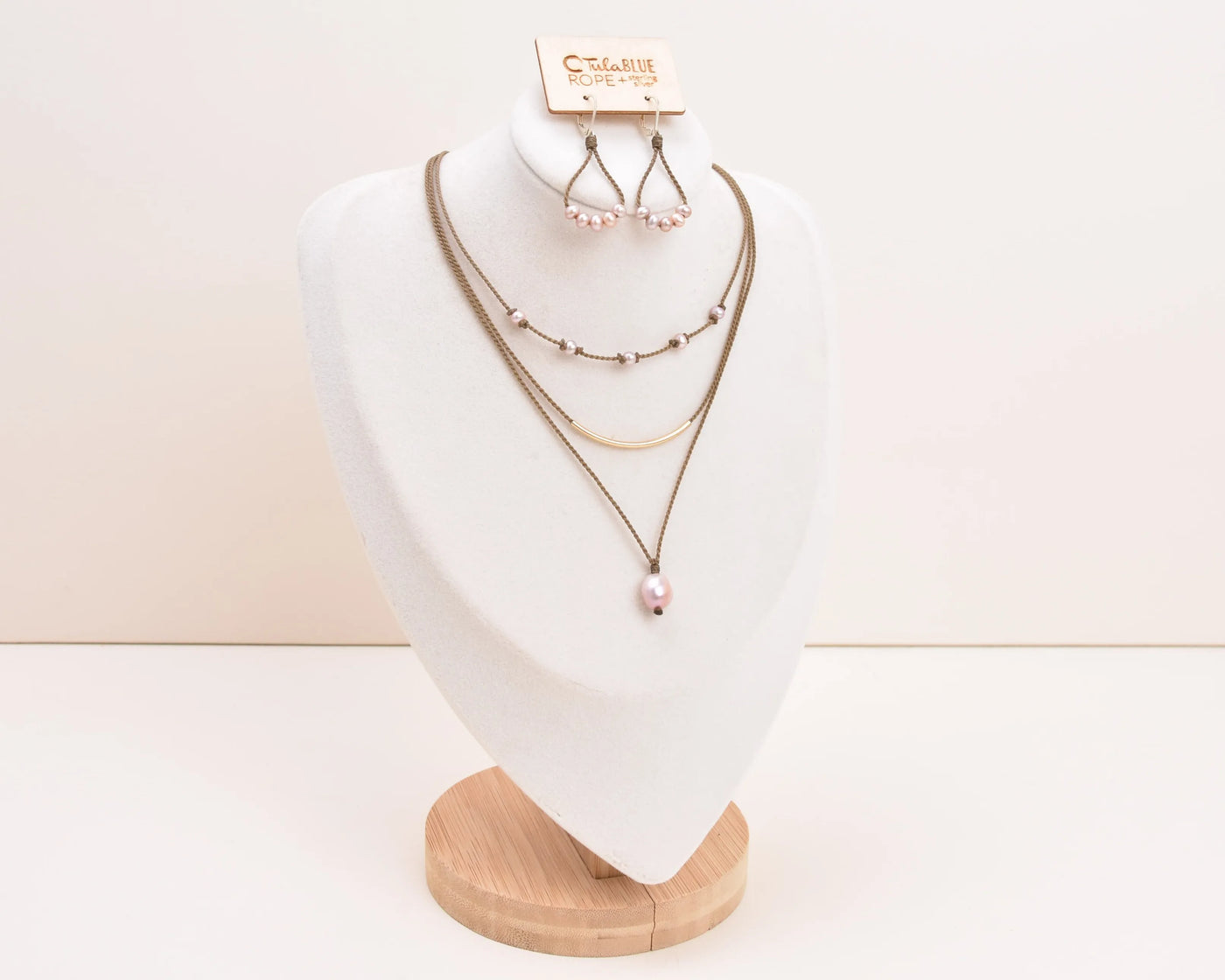 Dripping in Pearls necklace stack with earrings in blush on bust with white background