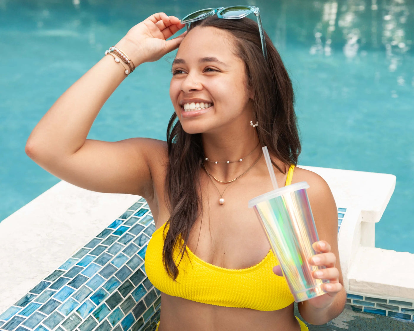 Dripping in Pearls necklace stack in white with earrings on model in swimming pool