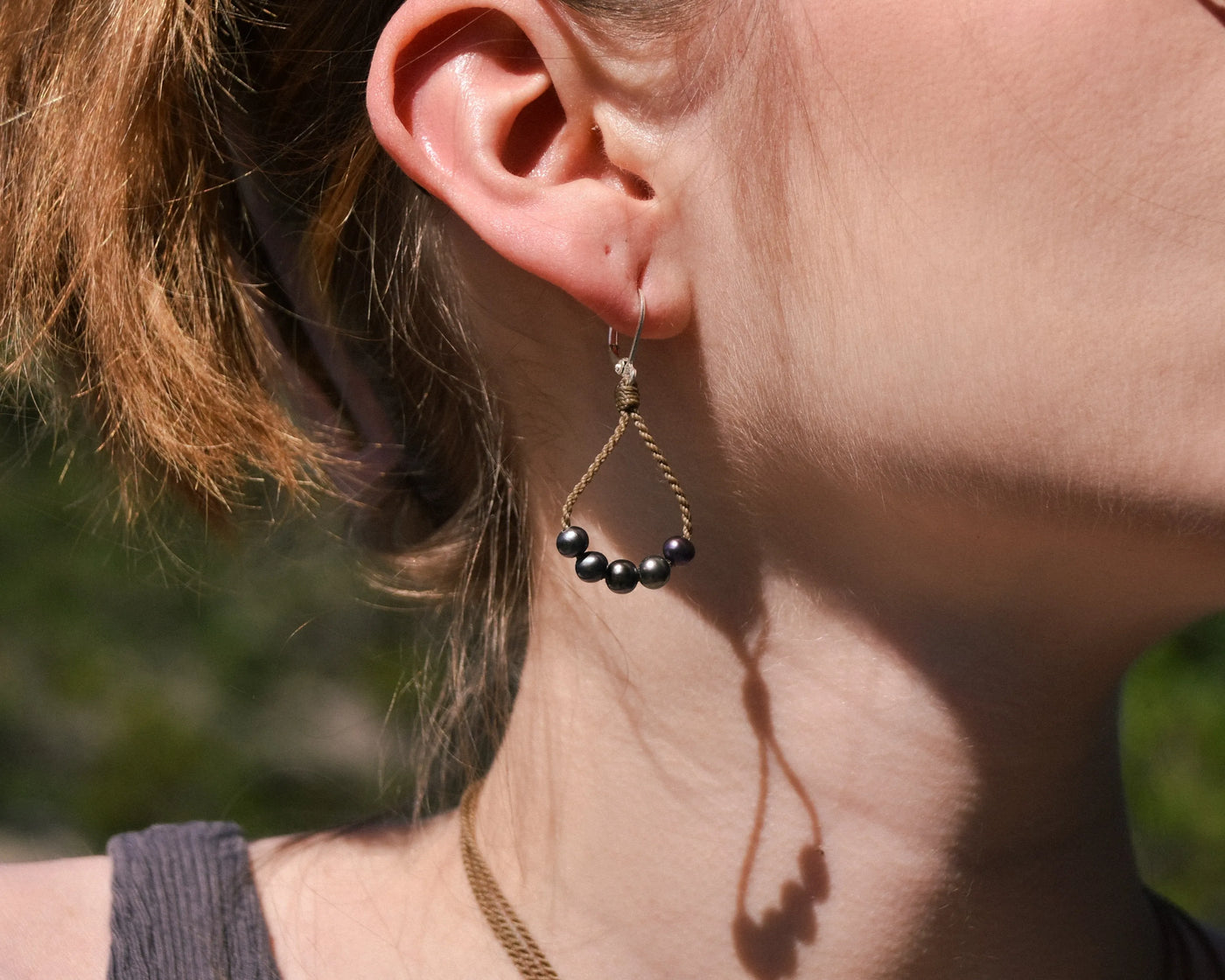 dainty pearl earrings closeup on model