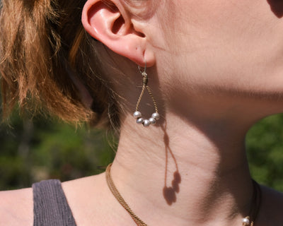 dainty pearl earrings in silver on model closeup