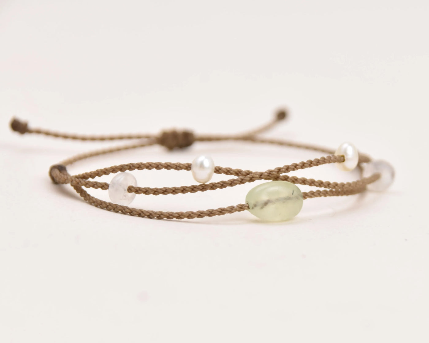 Mental Health Matters Riptide Bracelet single photo on white backgorund extreme closeup of prehnite center stone, freshwater pearls, and moonstone rondelles
