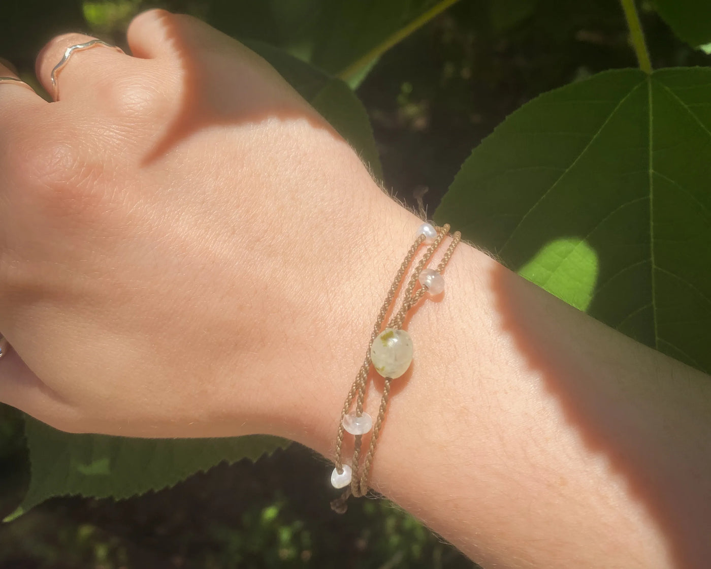 Mental Health Matters Riptide Bracelet on model's wrist with green leaves in background and sunlight