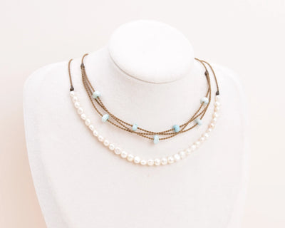 White Pearl Crown Necklace and Larimar Riptide necklace on white bust