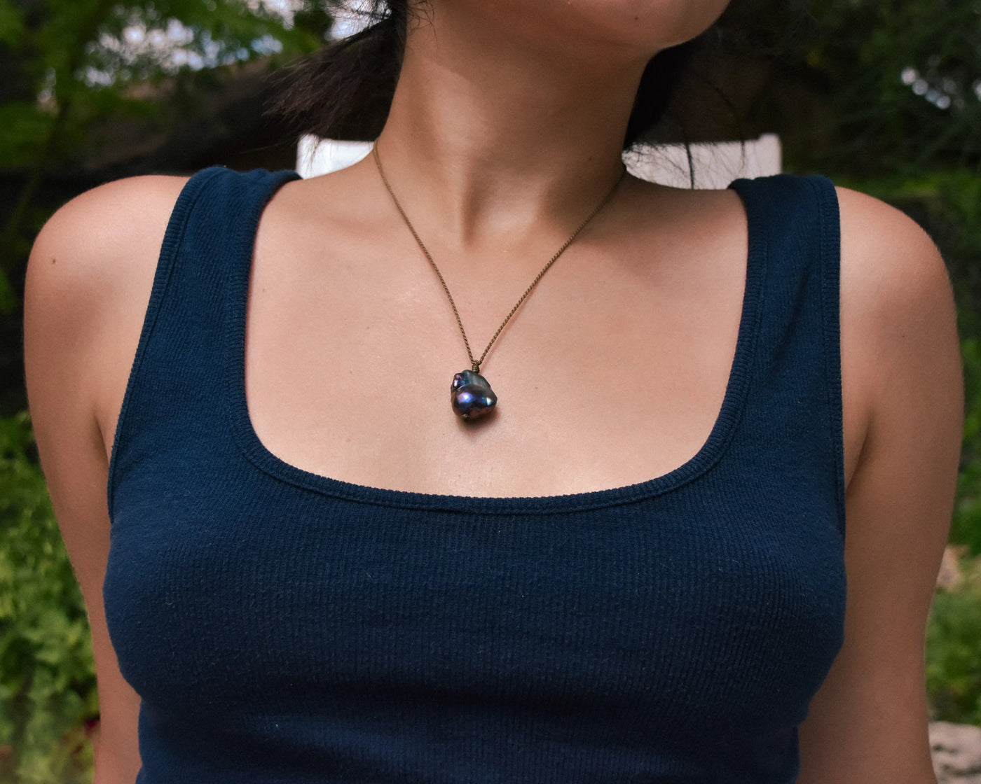 Peacock Flame Keshi Pearl Drop Necklace on a model with her reclining in a pool chair 