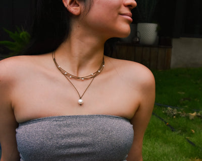 Pearl Drop Necklace in white on model paired with the white riptide necklace