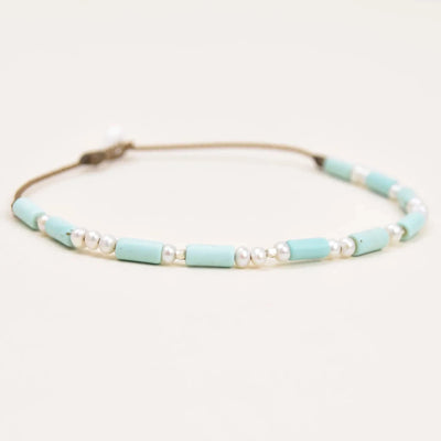 Turquoise, Pearl and Sterling Silver anklet layout on white background viewed at an angle