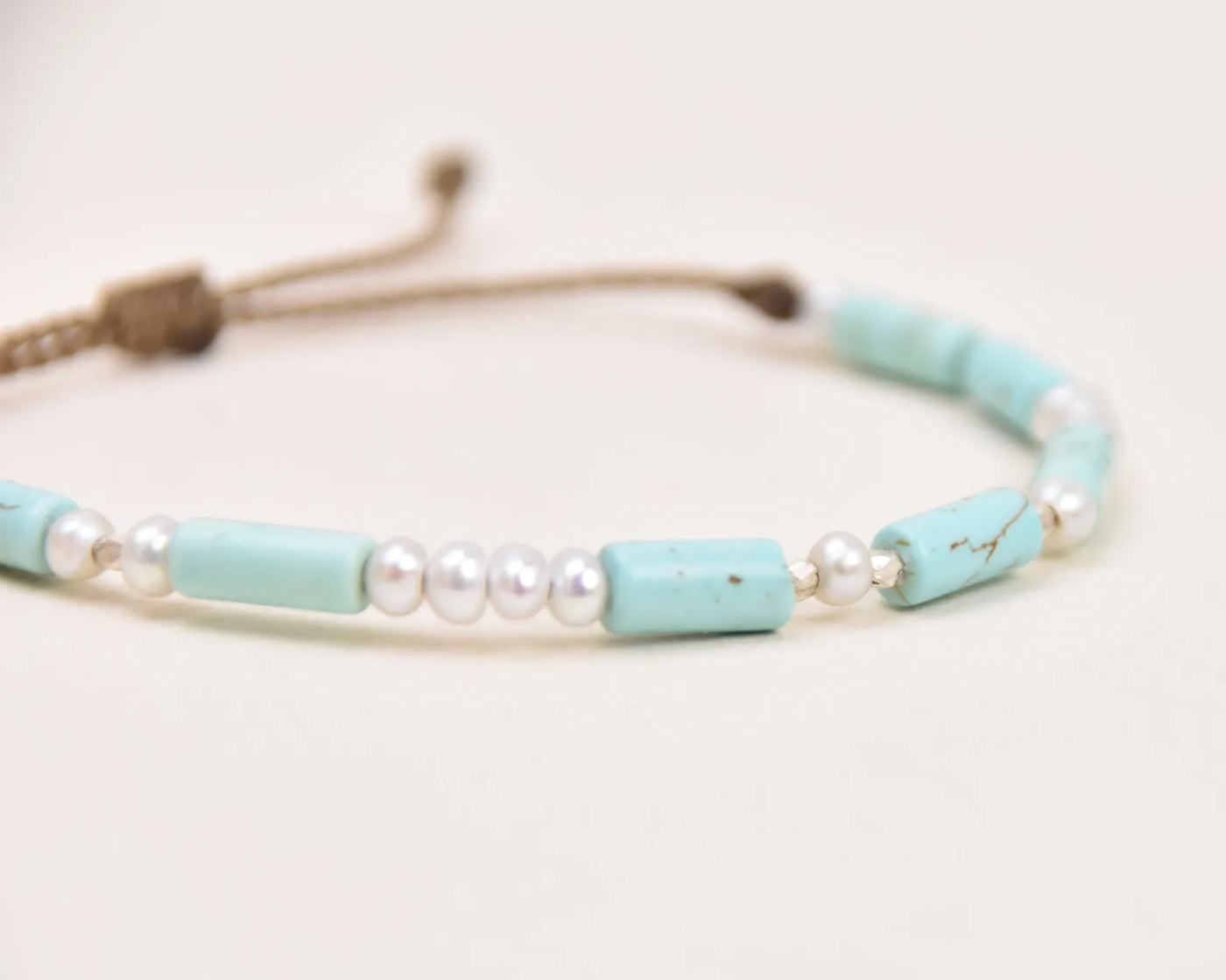 Turquoise, Pearl and Sterling Silver bracelet layout on white background viewed very closeup